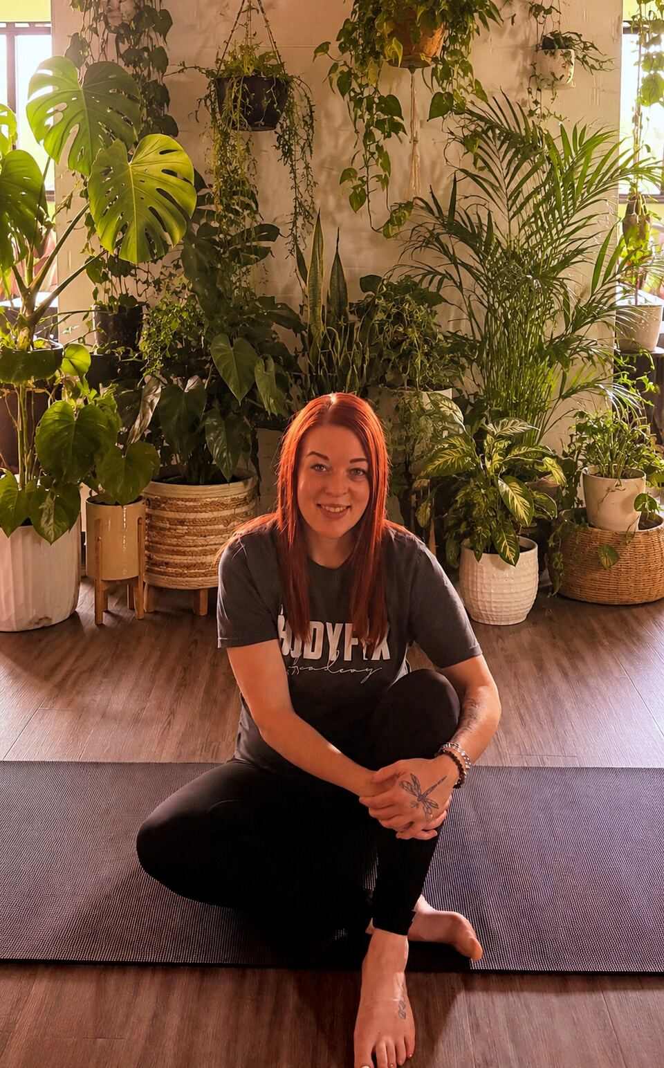 Amanda Willms seated in her plant-filled movement studio